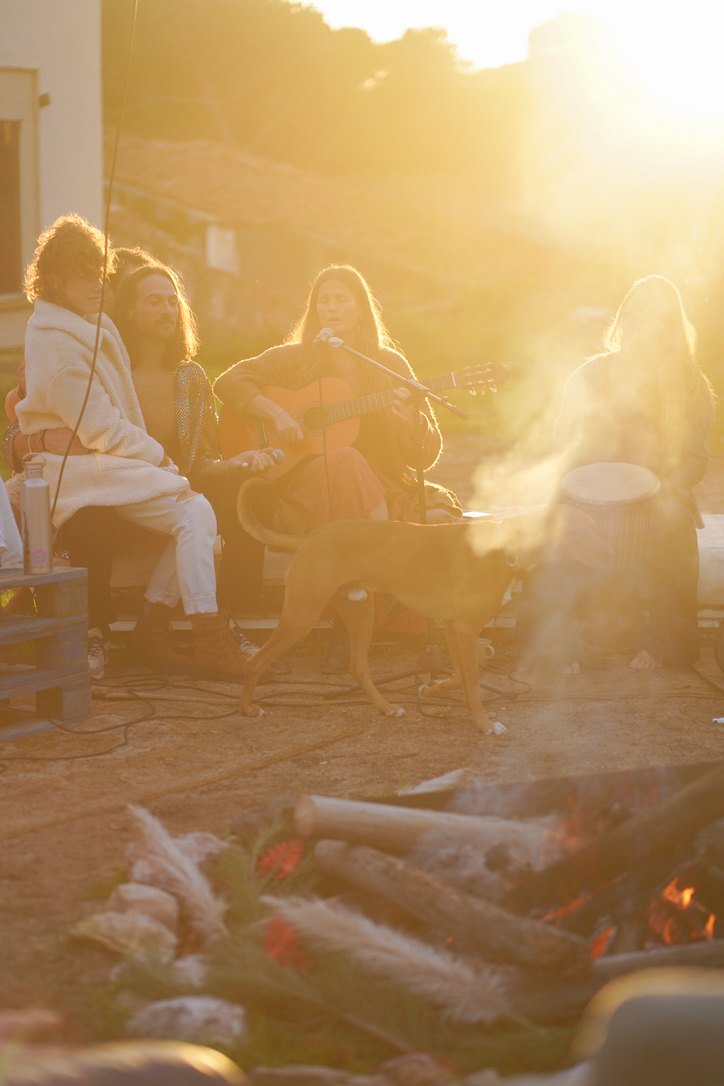 Retreat women gathered around a fire in golden evening light