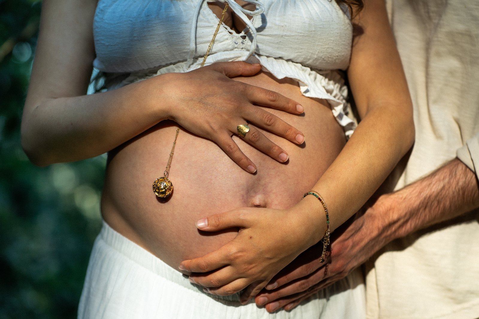 Hands resting together on a pregnant belly