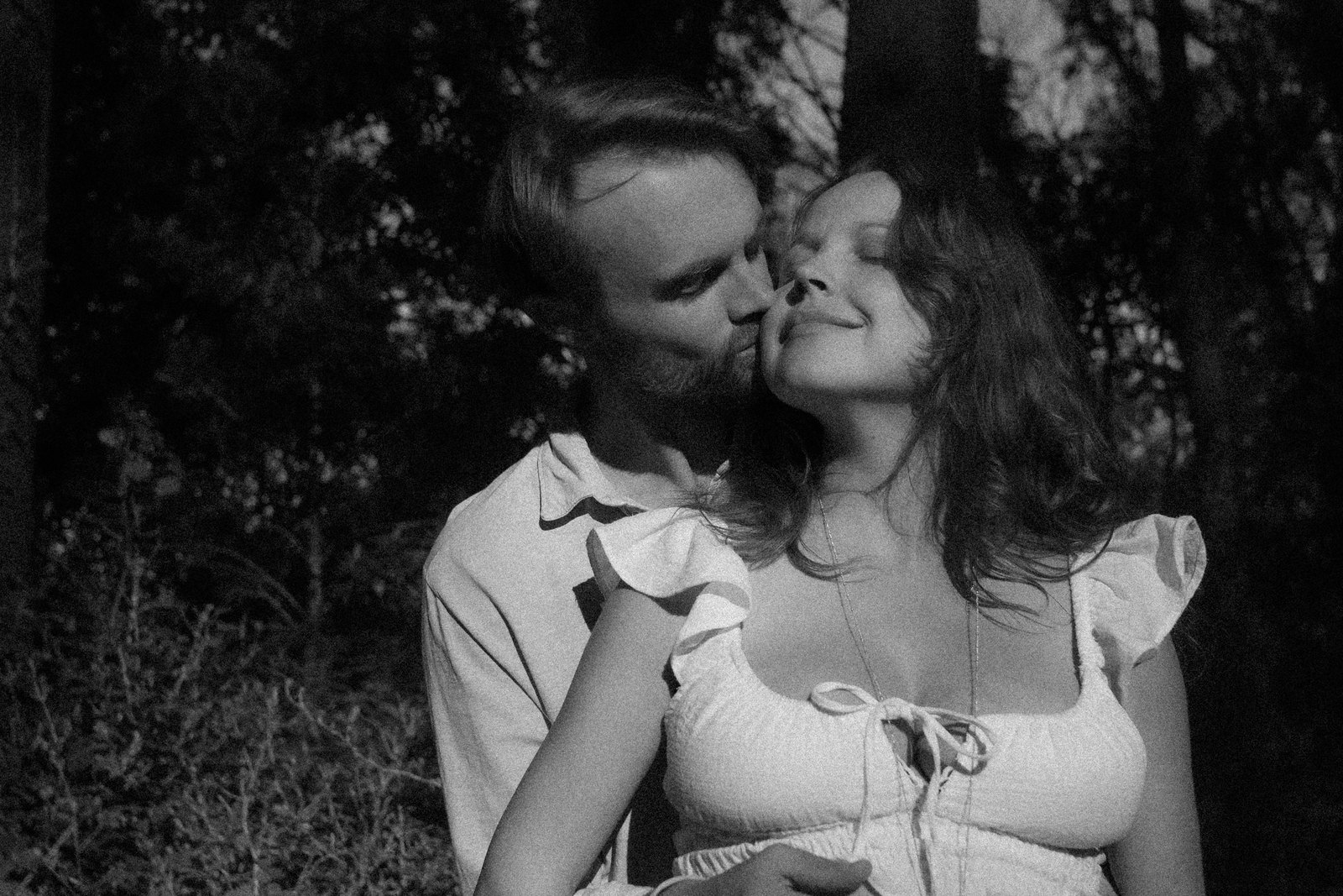Black and white kiss between expecting parents