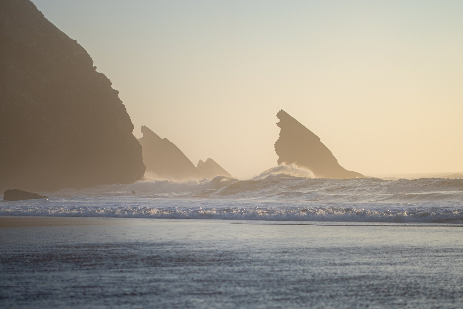Sea stacks and cliffs of Praia da Adraga, Sintra, in golden evening light